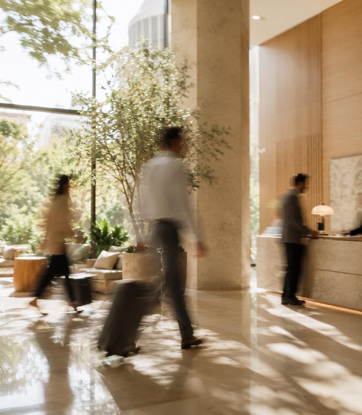 Guests moving through a hotel lobby at midday